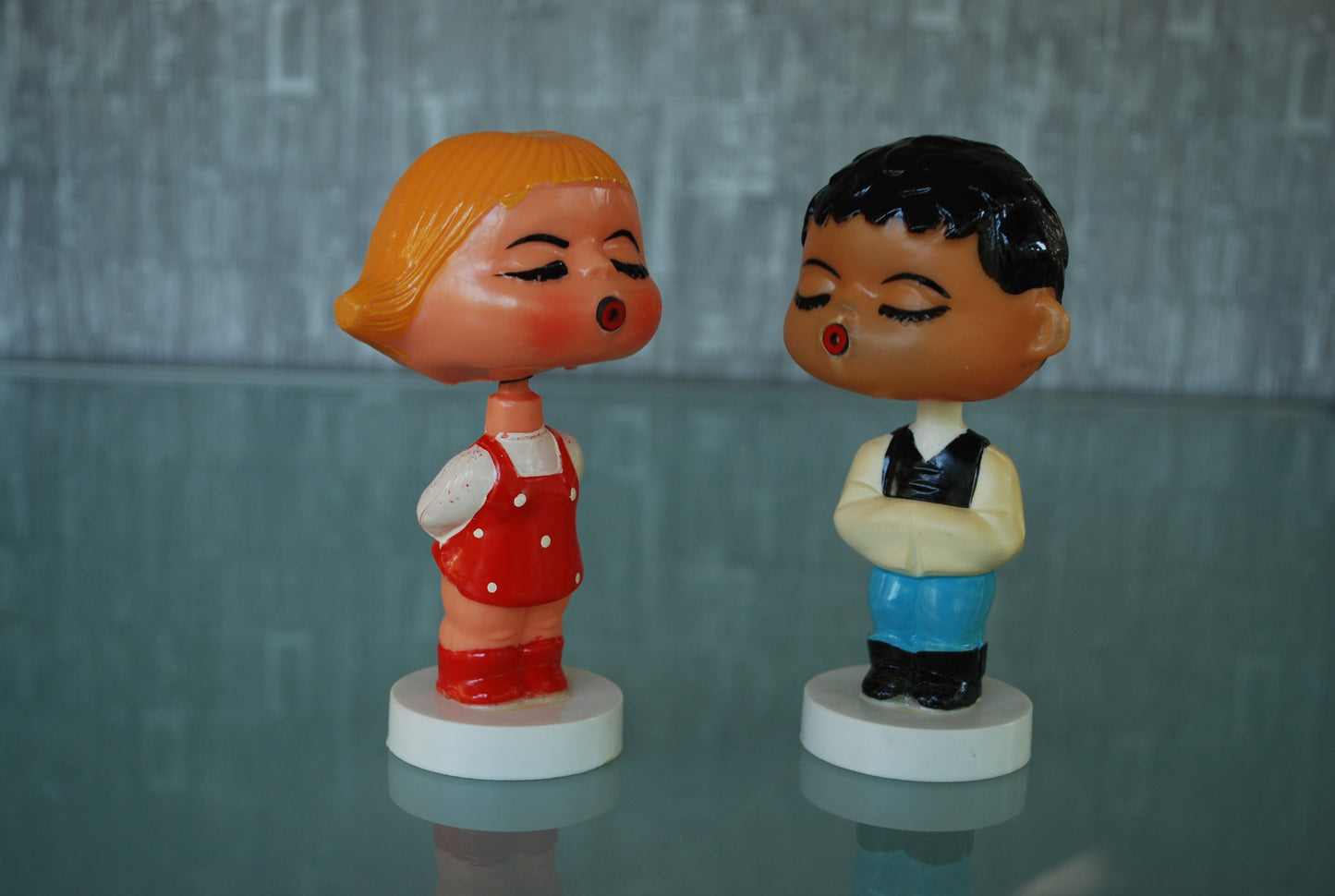 Kissing boy and girl bobblehead figures