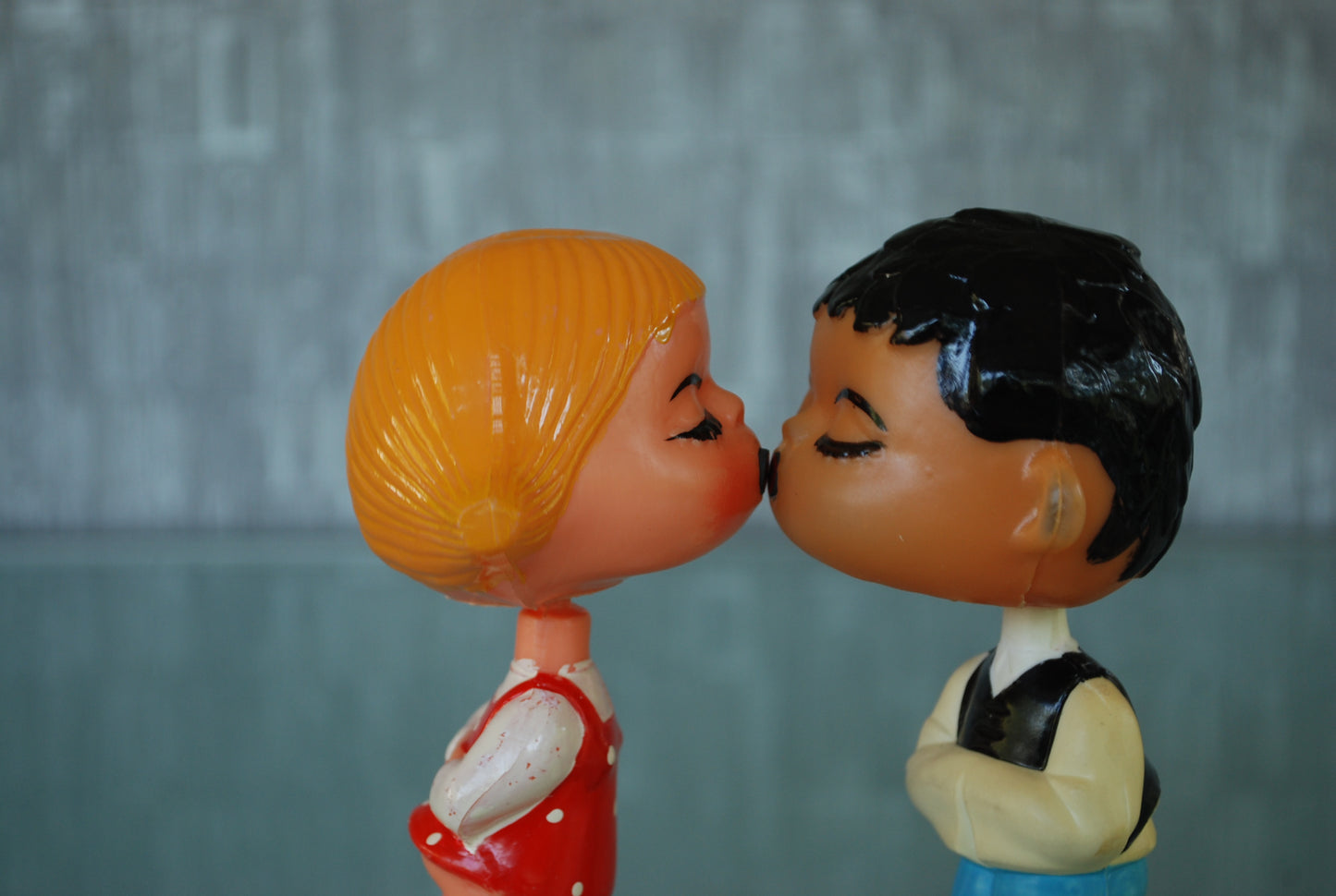 Kissing boy and girl bobblehead figures