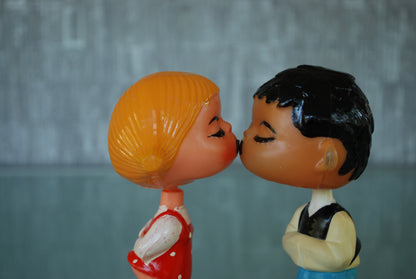 Kissing boy and girl bobblehead figures