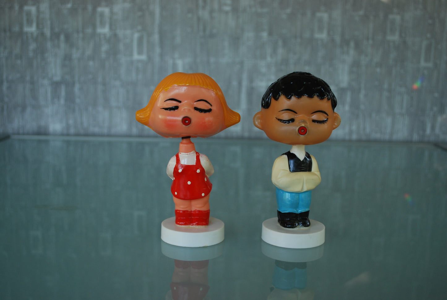 Kissing boy and girl bobblehead figures