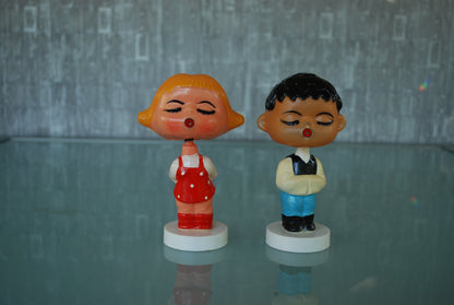 Kissing boy and girl bobblehead figures