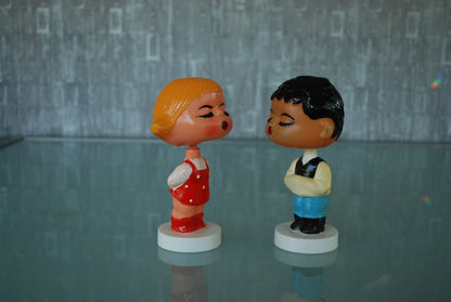 Kissing boy and girl bobblehead figures