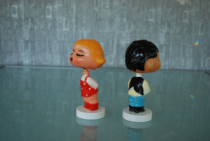 Kissing boy and girl bobblehead figures