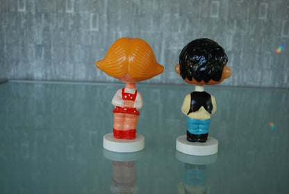 Kissing boy and girl bobblehead figures