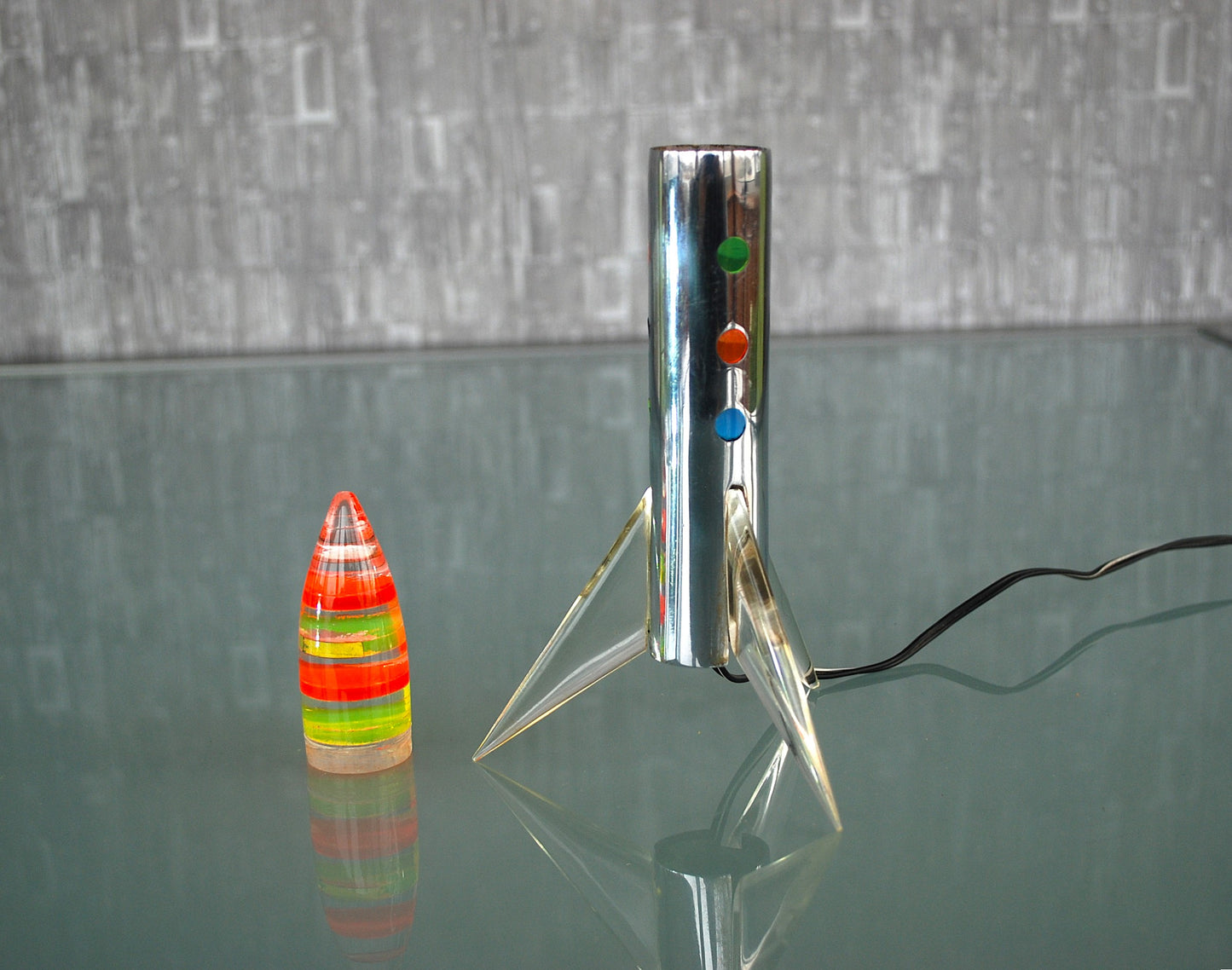 Raket lamp staand op 3 vleugels met gekleurde schijven punt. *