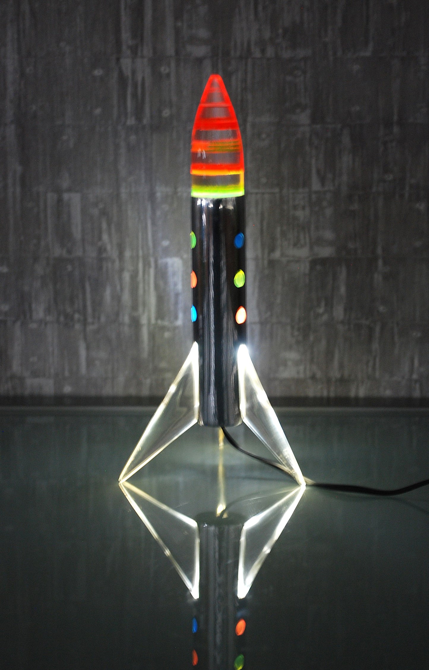 Raket lamp staand op 3 vleugels met gekleurde schijven punt. *