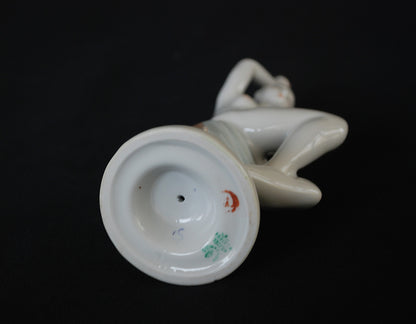 Naakte vrouw op boomstronk met blauwe handdoek