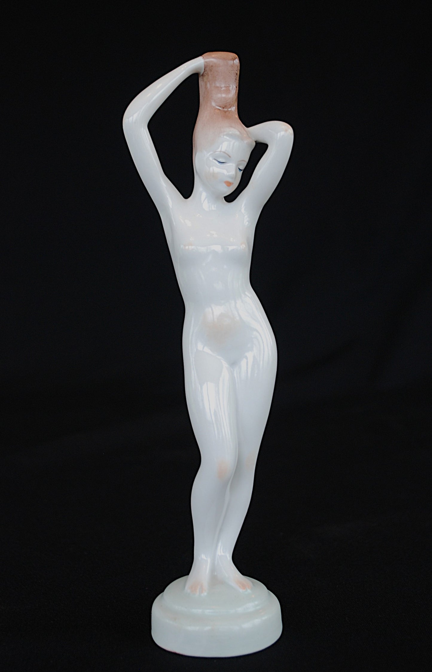 Naakt Vrouw staand met handen in het haar haren. Beeld