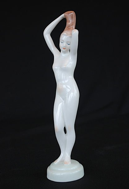 Naakt Vrouw staand met handen in het haar haren. Beeld