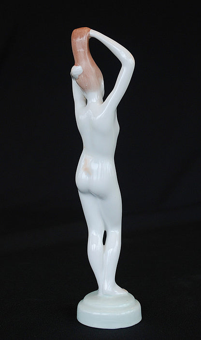 Naakt Vrouw staand met handen in het haar haren. Beeld