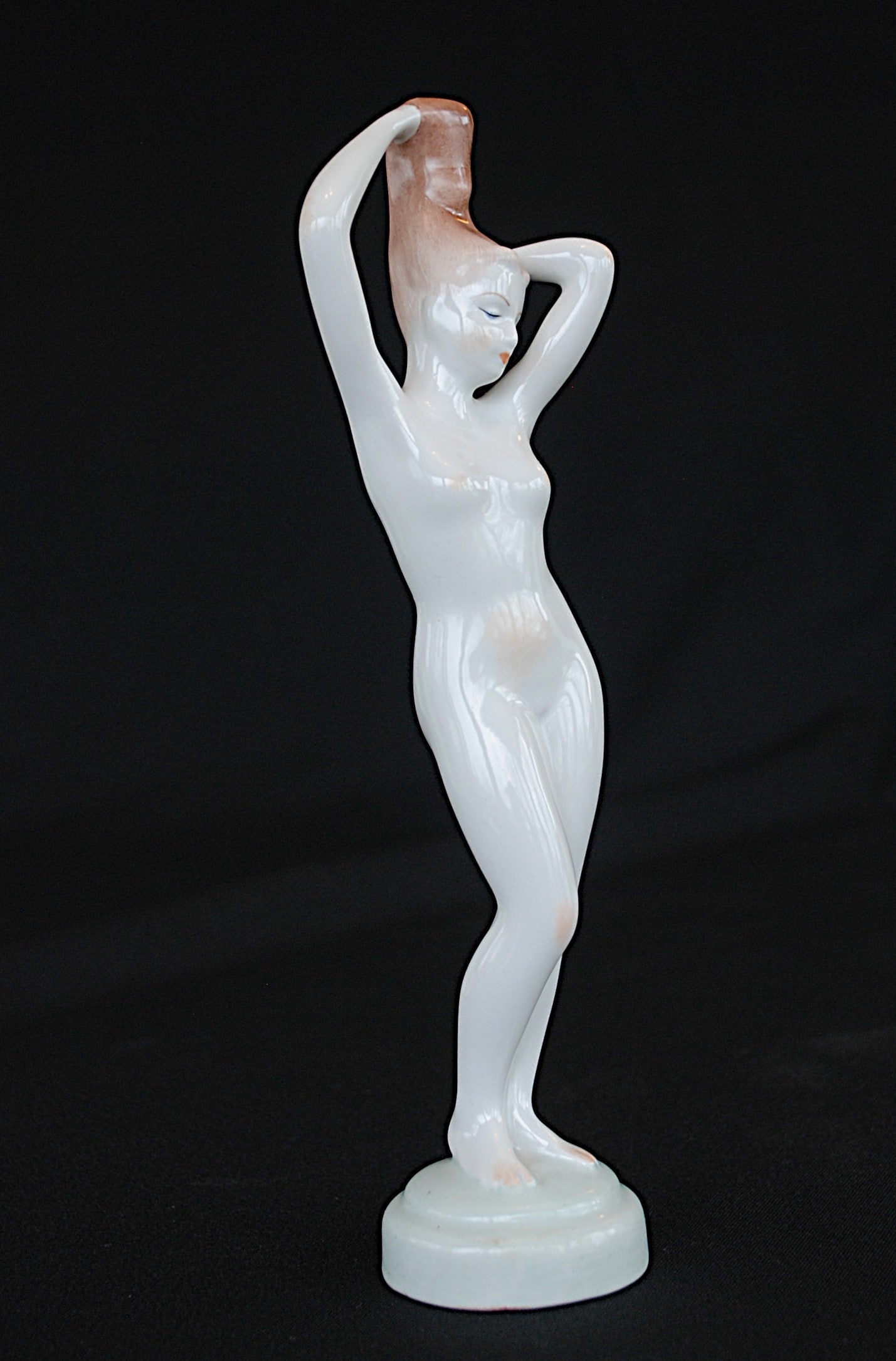 Naakt Vrouw staand met handen in het haar haren. Beeld