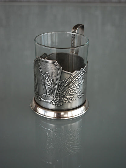 Sovjet theeglas houder met glas. Vrouw met Spoetnik in haar hand, reikt naar de sterren