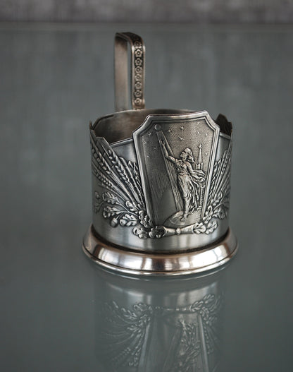 Sovjet theeglas houder met glas. Vrouw met Spoetnik in haar hand, reikt naar de sterren