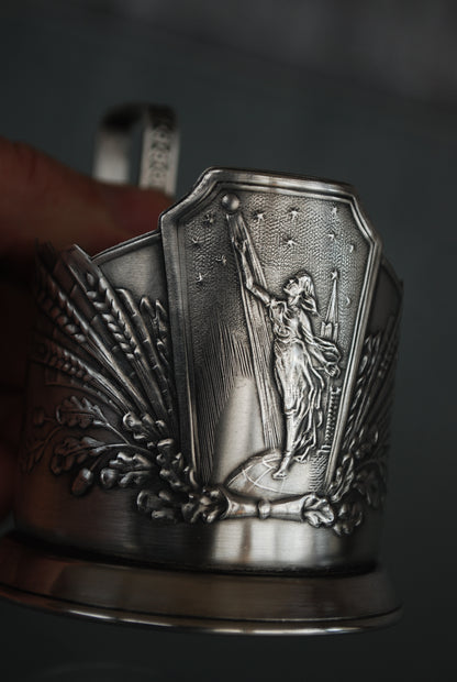 Sovjet theeglas houder met glas. Vrouw met Spoetnik in haar hand, reikt naar de sterren