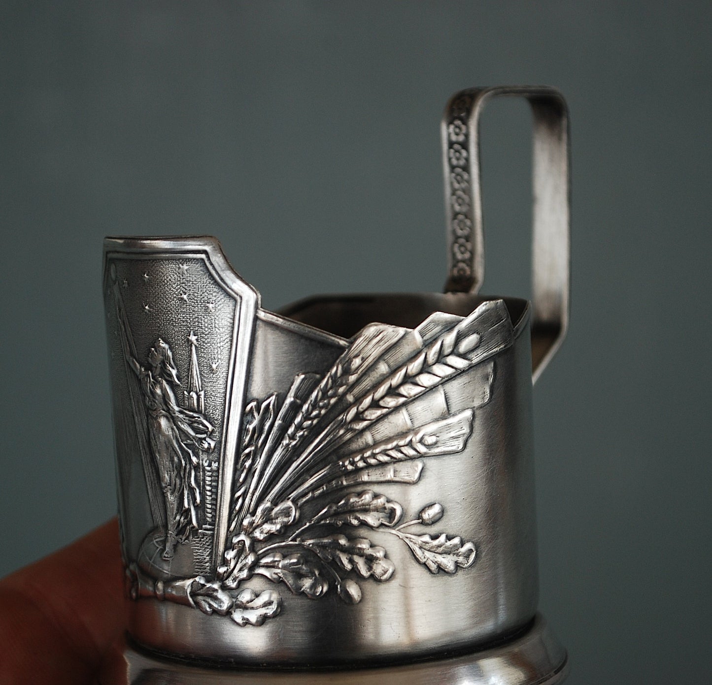 Sovjet theeglas houder met glas. Vrouw met Spoetnik in haar hand, reikt naar de sterren