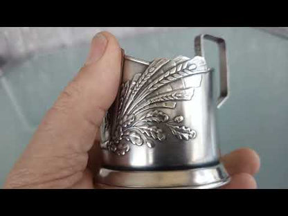 Sovjet theeglas houder met glas. Vrouw met Spoetnik in haar hand, reikt naar de sterren