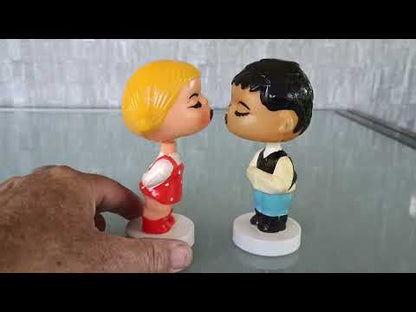 Kissing boy and girl bobblehead figures
